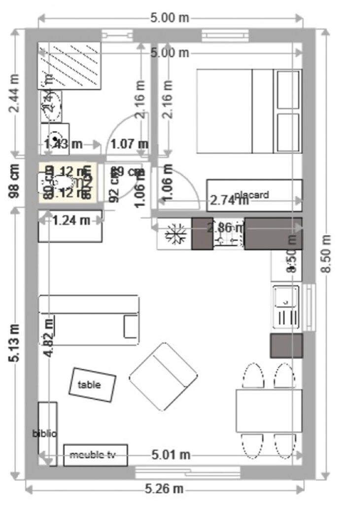 Plan détaillé d'une maison compacte montrant l'agencement des pièces, incluant une cuisine, une salle de bain, une chambre, et un espace salon-salle à manger